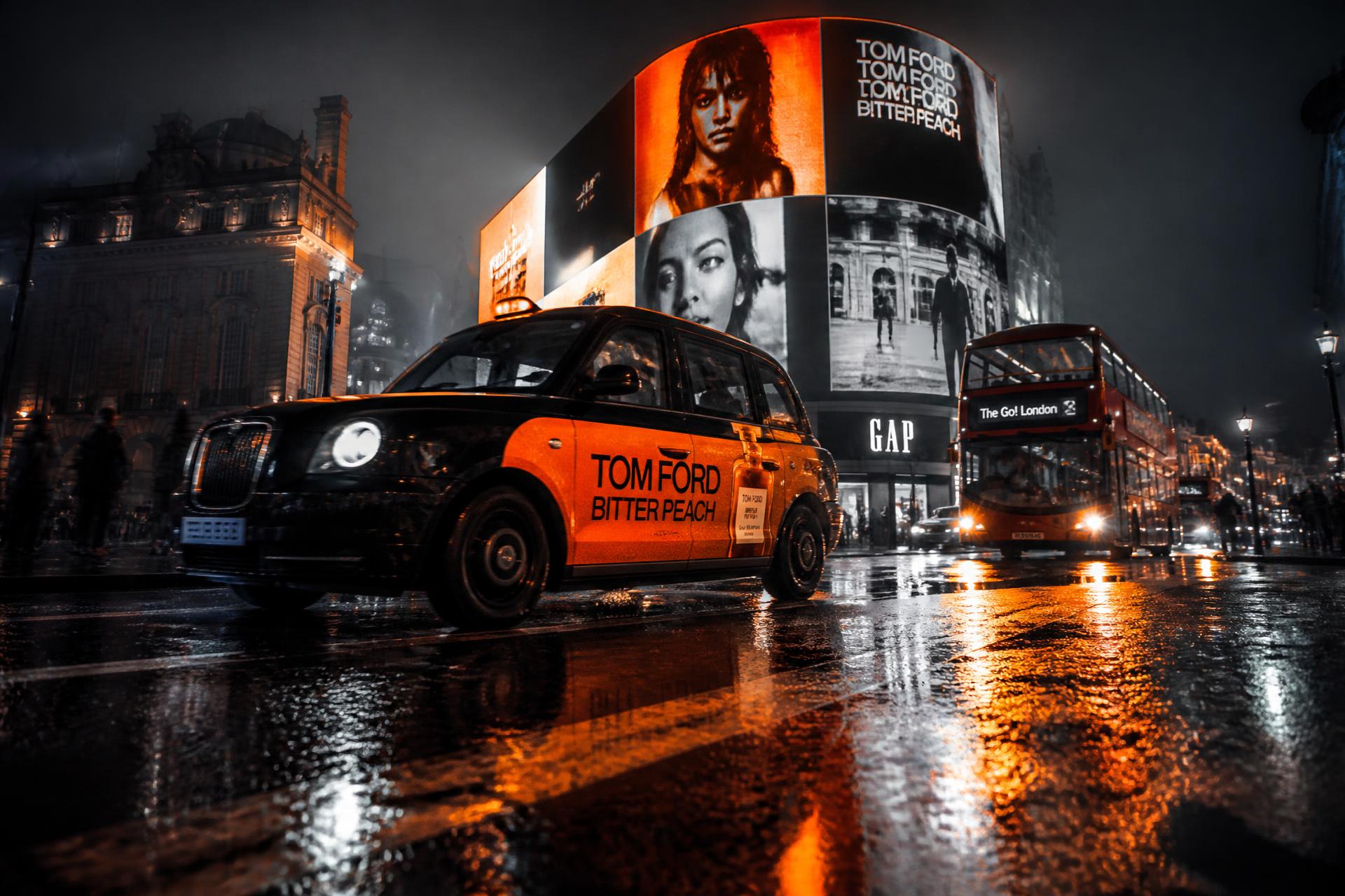 Neon-lit London street at night with taxi and billboards